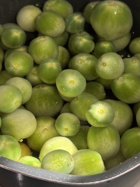 鍋で湯どおし中の青いトマト